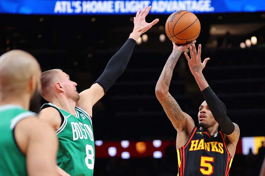Dejounte Murray of the Atlanta Hawks shoots a basket against Kristaps Porzingis of the Boston Celtics during overtime