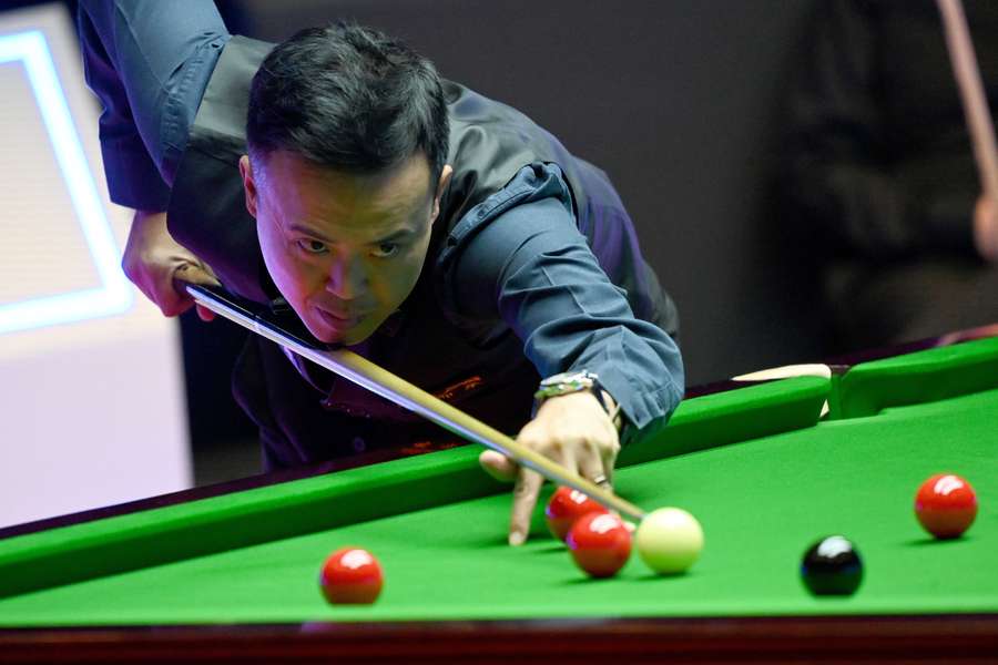 Marco Fu of Hong Kong lines up a shot during the first semi-final match against John Higgins at the Hong Kong Masters