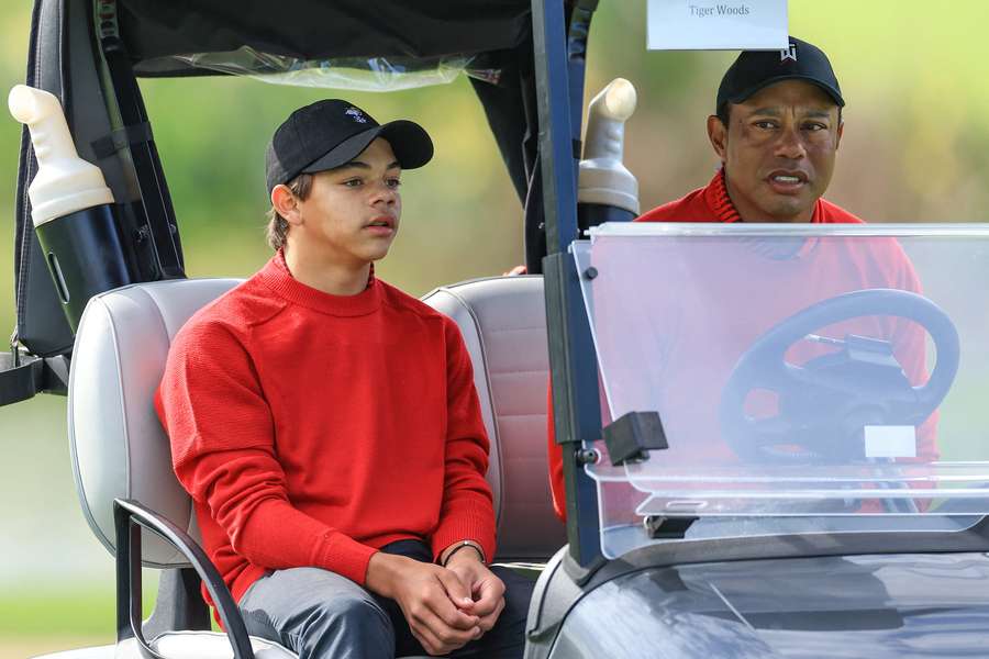 Tiger Woods of The United States rides a cart with his son Charlie Woods