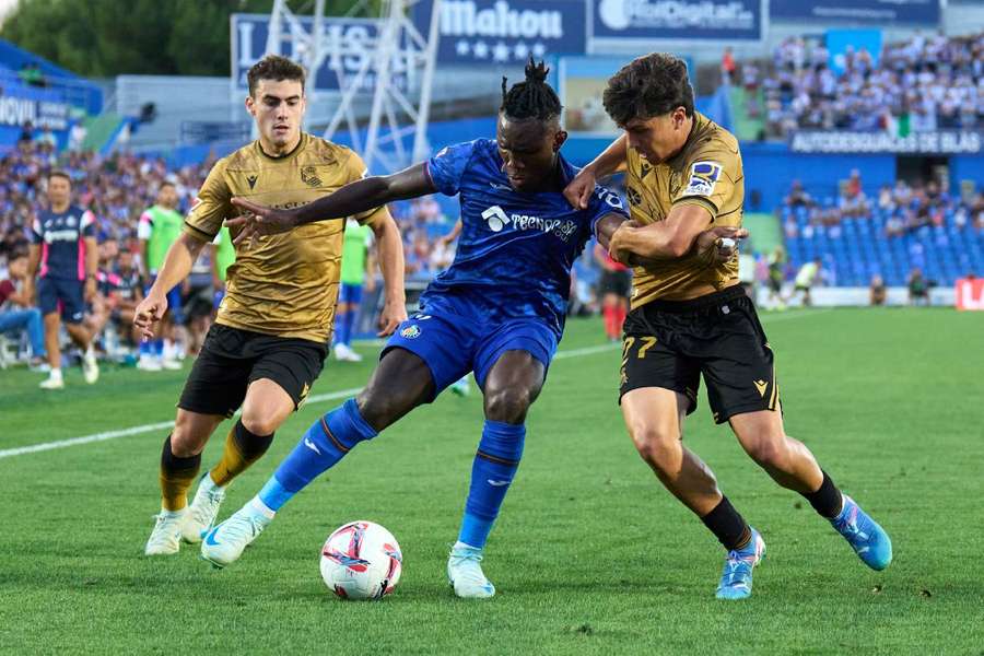 Uche, jugador del Getafe, ante Barrenetxea y Aramburu, jugadores de la Real