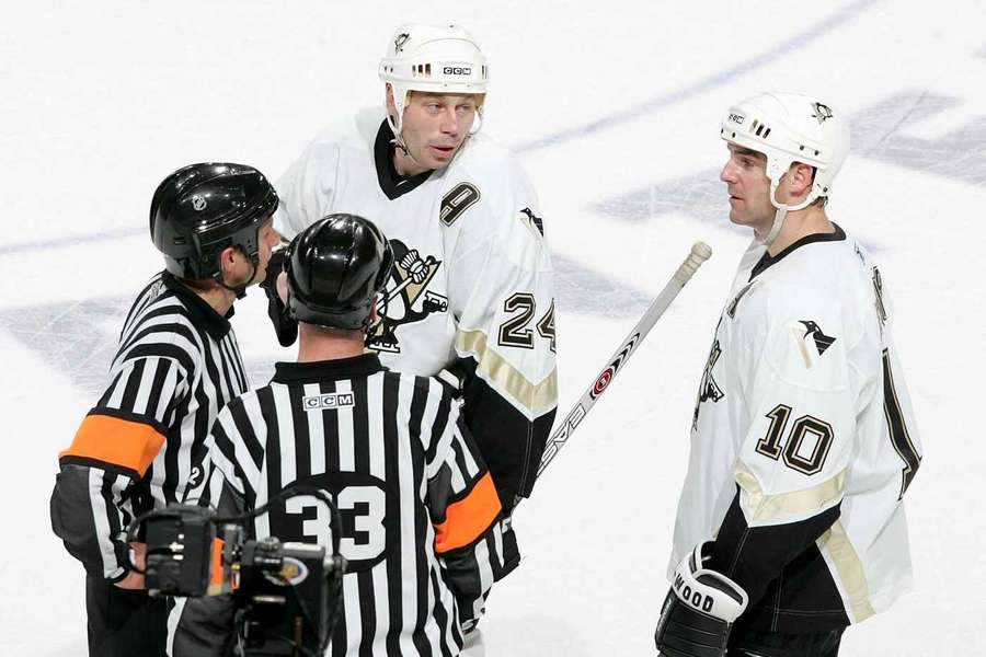 Lyle Odelein (vlevo) a jeho spoluhráč z Pittsburghu John LeClair (vpravo) v debatě s rozhodčími. Lyle Odelein (vlevo) a jeho spoluhráč z Pittsburghu John LeClair (vpravo) v debatě s rozhodčími.