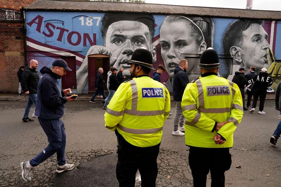 Police officers look on as Aston Villa fans walk past a mural of Aston Villa's players Ollie Watkins, Rachel Daly and goalkeeper Emiliano Martinez Police officers look on as Aston Villa fans walk past a mural of Aston Villa's players Ollie Watkins, Rachel Daly and goalkeeper Emiliano Martinez