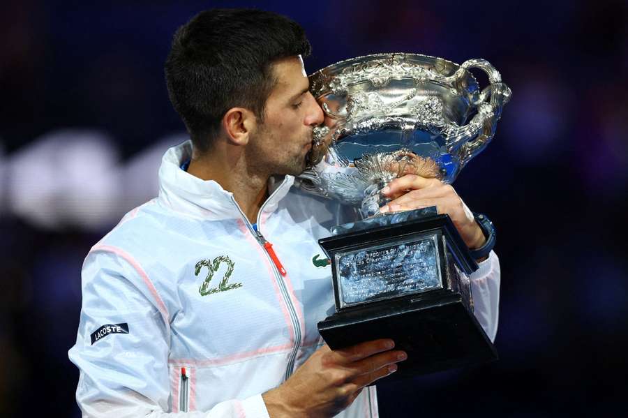 Novak Djokovic poses with his trophy after winning