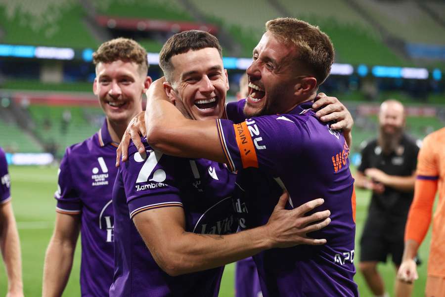Perth Glory hero Tom Lawrence celebrates their win at Melbourne City with teammate Scott Wootton. 