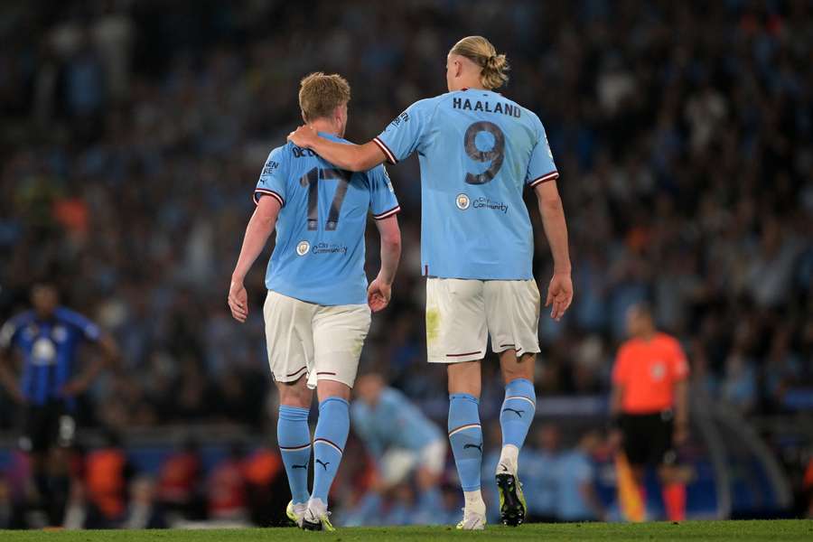 Kevin De Bruyne is consoled by Erling Haaland after being injured in the final