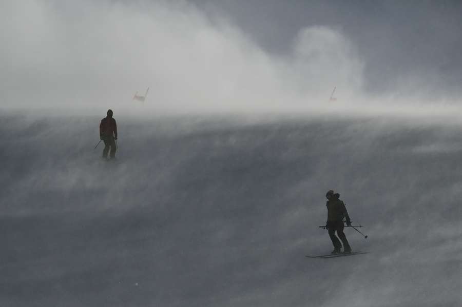 Staff work on the slope before the women's downhill was cancelled due to strong winds