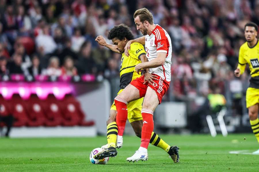 Bayerns Harry Kane im Zweikampf mit Dortmunds Karim Adeyemi.