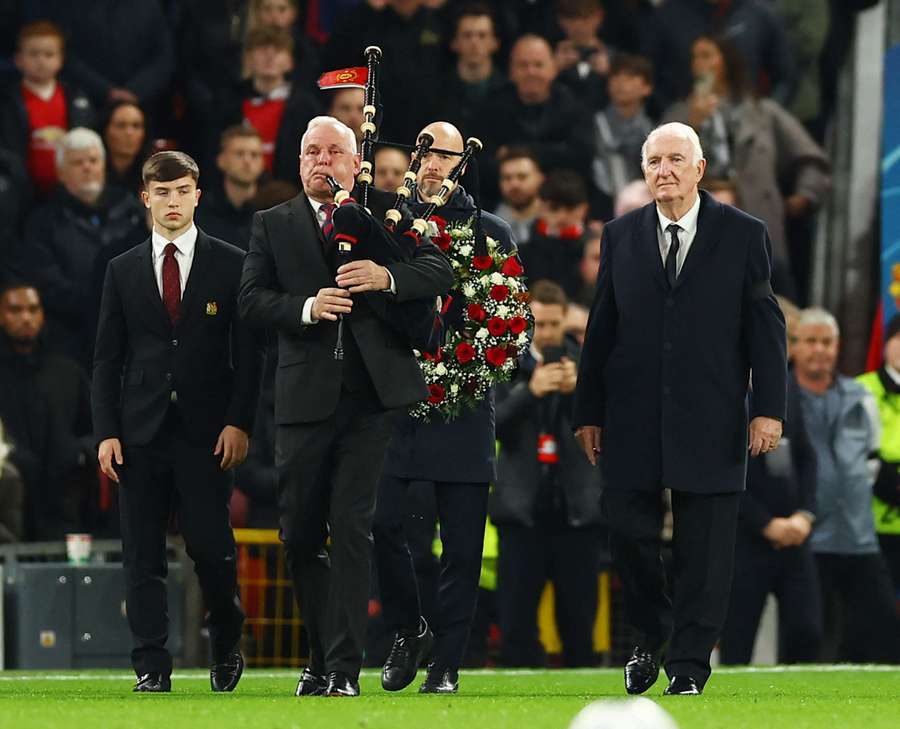 O treinador do Manchester United, Erik ten Hag, segura uma coroa de flores em memória do antigo jogador do Manchester United Bobby Charlton