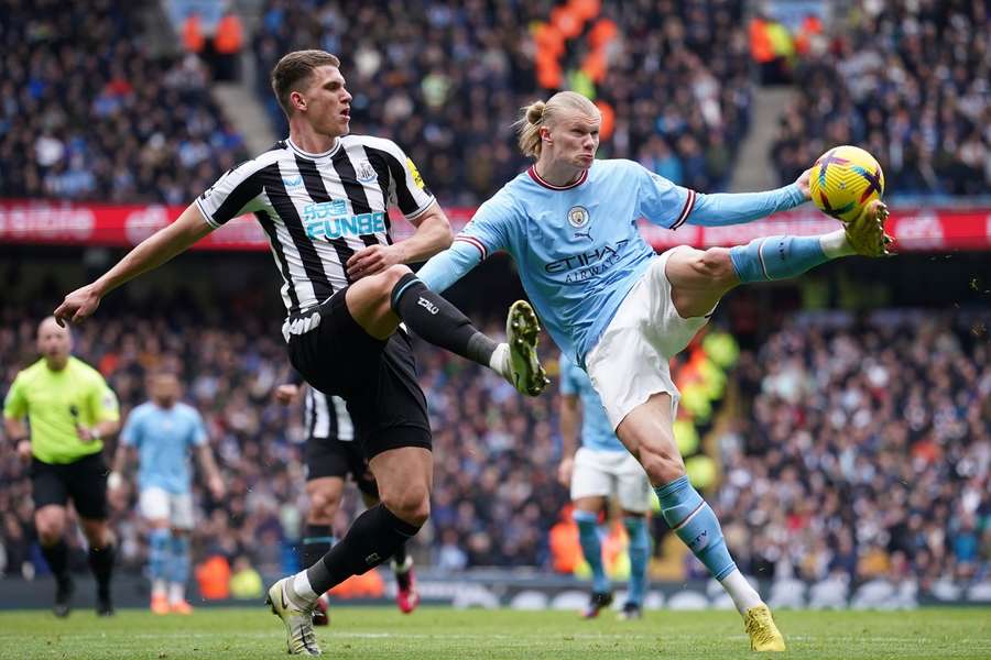 Manchester City's Erling Haaland (R) challenges for the ball with Newcastle's Sven Botman