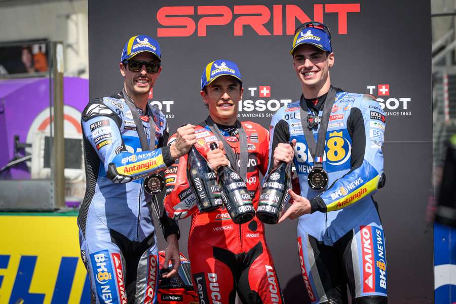 Marc Marquez sărbătorește pe podium, flancat de fratele său Alex Marquez și de Fermin Aldeguer, clasat pe locul al treilea