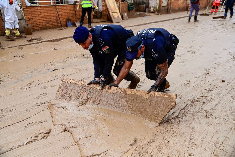 Operarios de policía retiran lodo en Alfafar (Valencia) tras la DANA