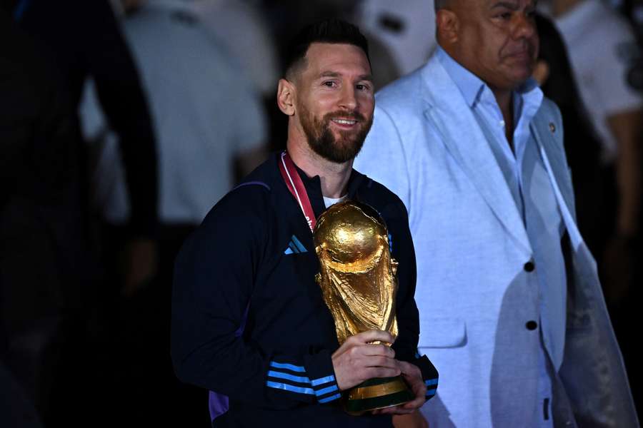 Argentina's captain and forward Lionel Messi holds the FIFA World Cup trophy