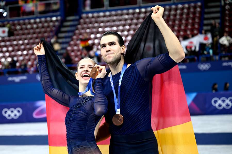 Minerva Fabienne ⁠Hase (left) and Nikita Volodin (right) celebrate their bronze medal at the 2026 Winter Olympics