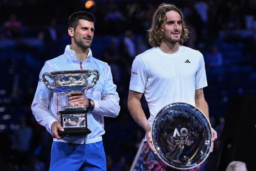 Serbia's Novak Djokovic holds the Norman Brookes Challenge Cup with Greece's Stefanos Tsitsipas