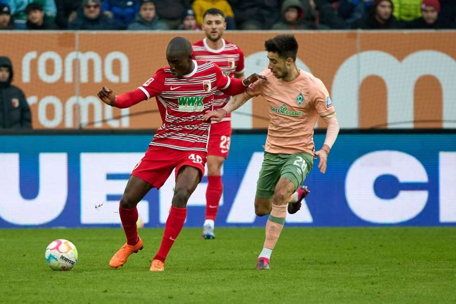 Kelvin Yeboah (li.) vom FC Augsburg schirmt gegen Ilia Grüv (SV Werder Bremen) den Ball ab. 