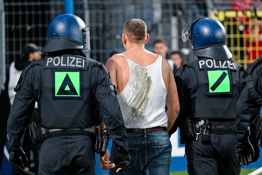 Die Polizei führt einen Unruhestifter ab. Die Polizei führt einen Unruhestifter ab.