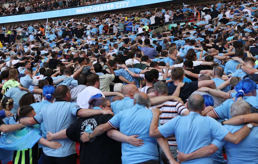 Os torcedores do Manchester City fazem a comemoração de Poznan antes do início da partida
