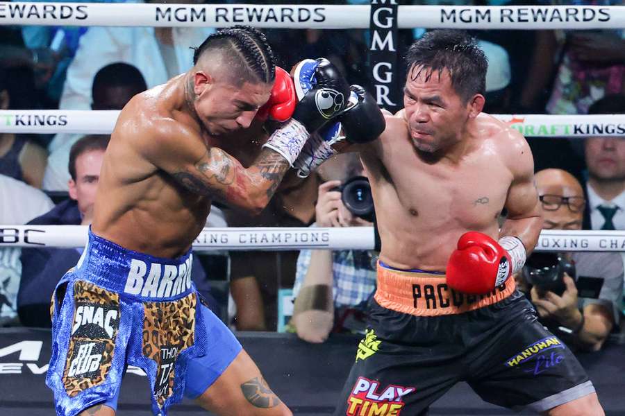 Manny Pacquiao (R) connects with Mario Barrios during their WBC welterweight title fight that ended in a majority draw