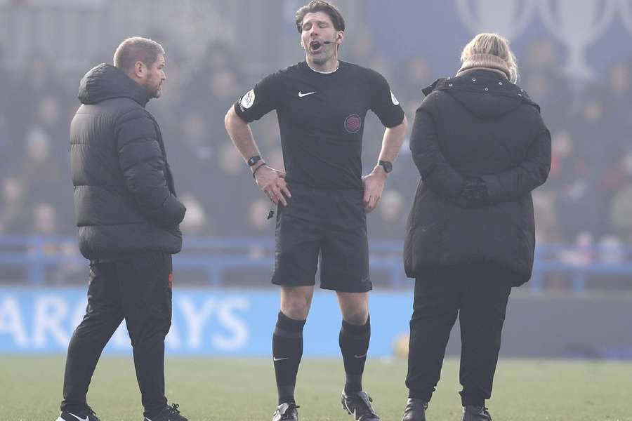 Scheidsrechter Paul Howard overlegt met trainers Emma Hayes (R) van Chelsea en Matt Beard van Liverpool