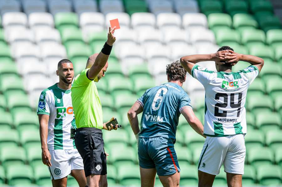 Scheidsrechter Rob Dieperink geeft een rode kaart aan Nordin Musampa