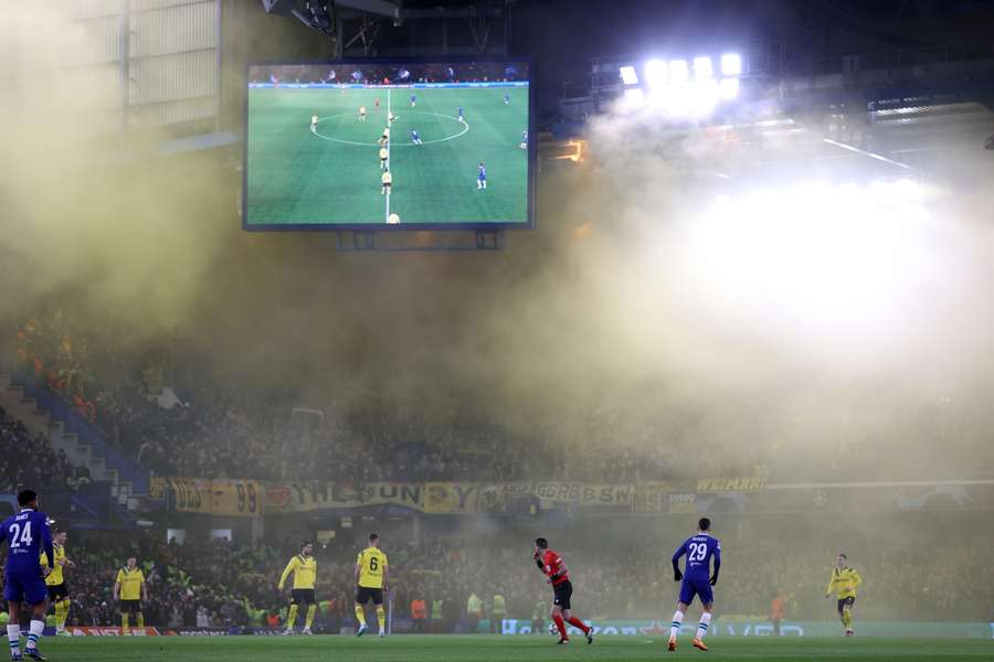 Yellow smoke from flares let off by Dortmund fans fills Stamford Bridge at kick-off