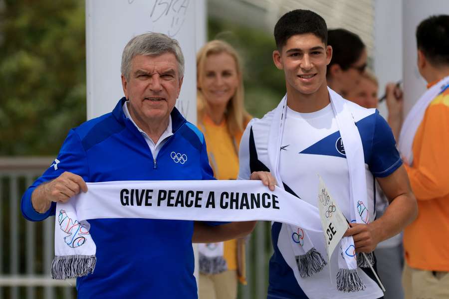 Il presidente del Cio, Thomas Bach, e Niv Yehoshua del Team Israele posano fuori dal Villaggio olimpico durante l'appello alla pace