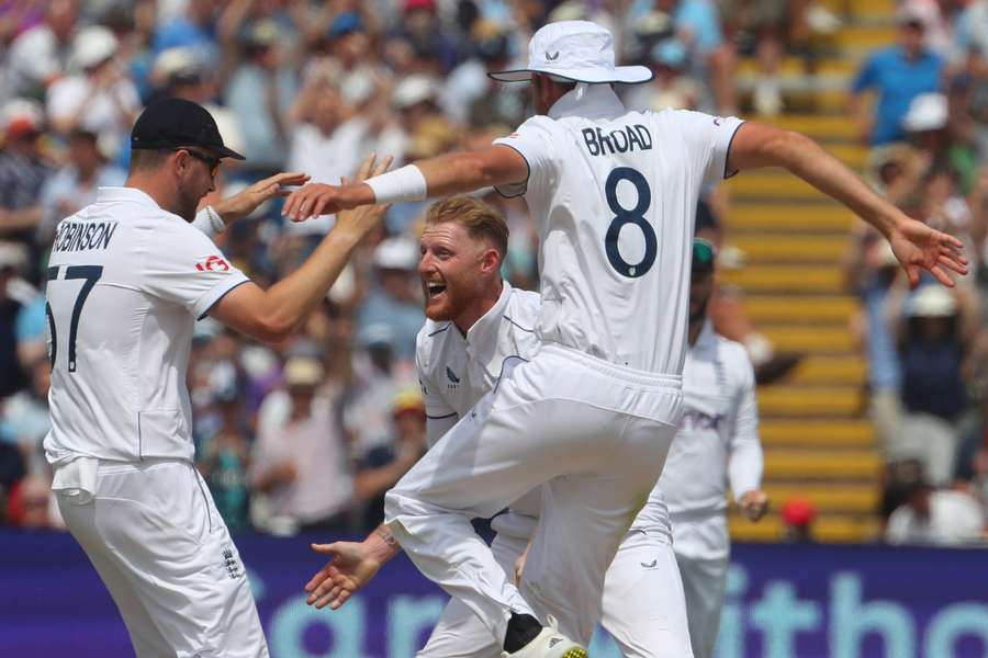 England's captain Ben Stokes (C) celebrates with England's Ollie Robinson (L) and England's Stuart Broad (R) after taking the wicket of Australia's Steve Smith