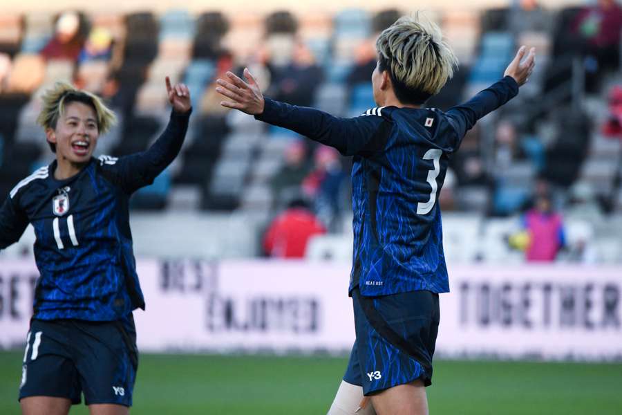 Moeka Minami celebrates with teammates after scoring Japan's fourth goal.