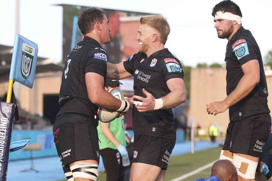 Henco Venter celebrates with team-mates after scoring in the corner