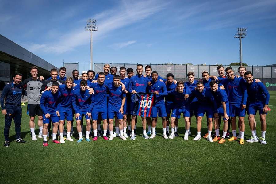 Ansu Fati, junto com seus companheiros de equipe, posando com a camisa comemorativa de suas 100 partidas pelo Barça.