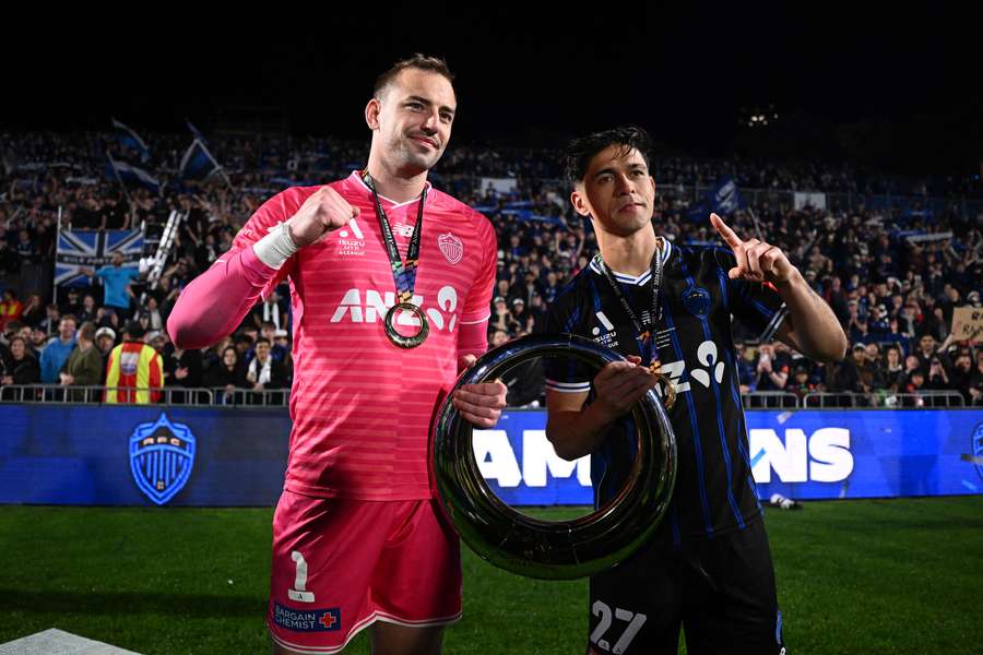 New Zealand goalkeeper Michael Woud holds the A-League trophy with Auckland teammate Logan Rogerson. New Zealand goalkeeper Michael Woud holds the A-League trophy with Auckland teammate Logan Rogerson.