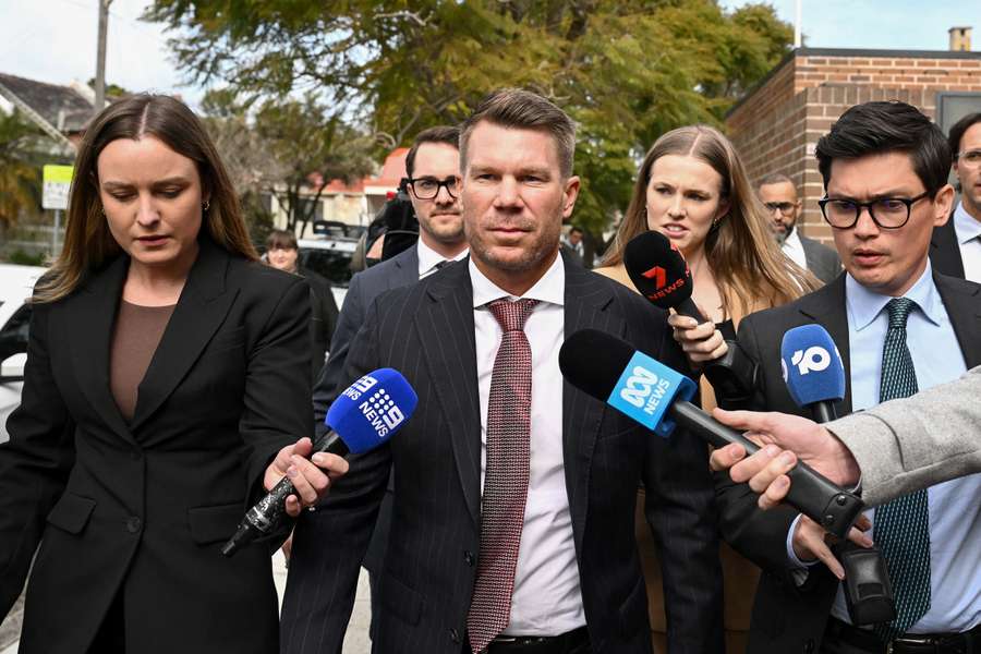 David Warner is mobbed by reporters after leaving a Sydney court on Tuesday.