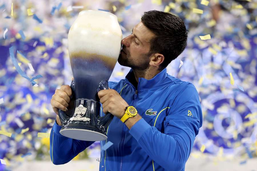 Novak Djokovic kust de beker na zijn zinderende zege op Carlos Alcaraz