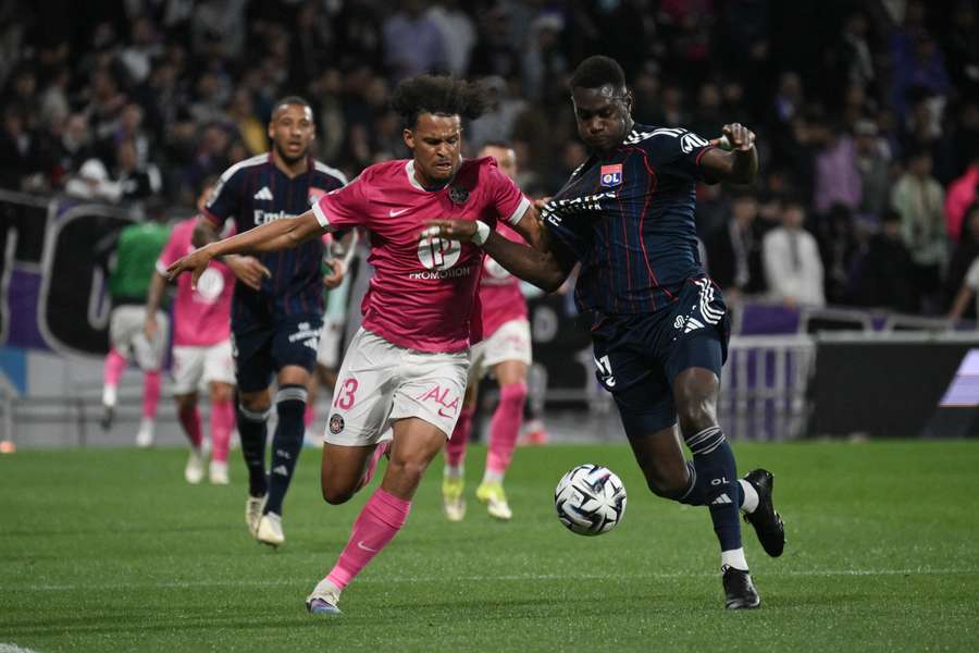 Toulouse's Jacen Russel-Rowe (left) fights for the ball with Lyon's Moussa Niakhate