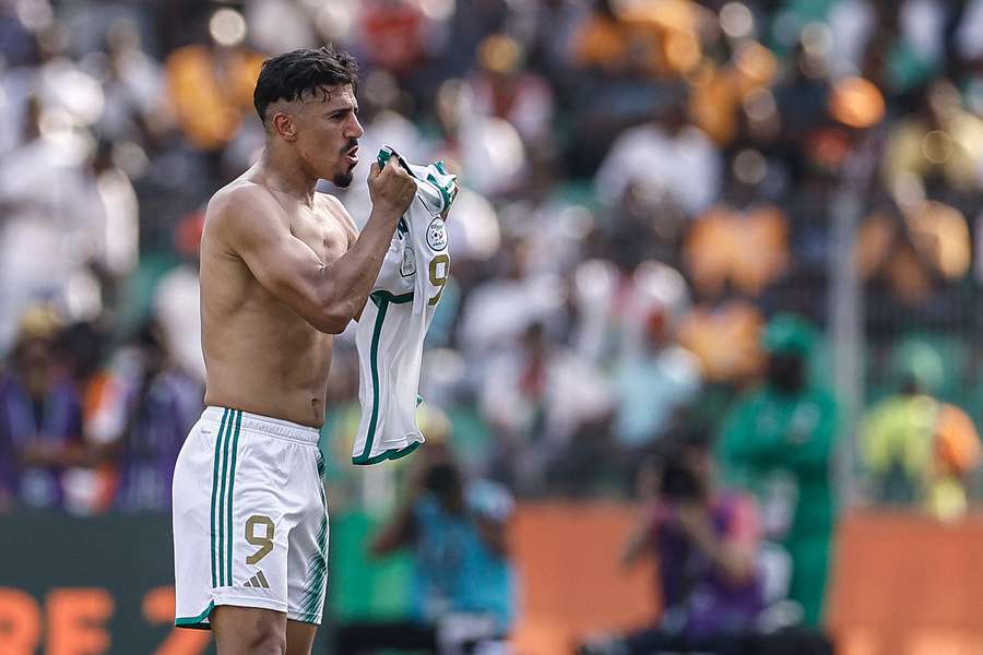 Algeria's Baghdad Bounedjah shows his jersey as he celebrates scoring the late equaliser