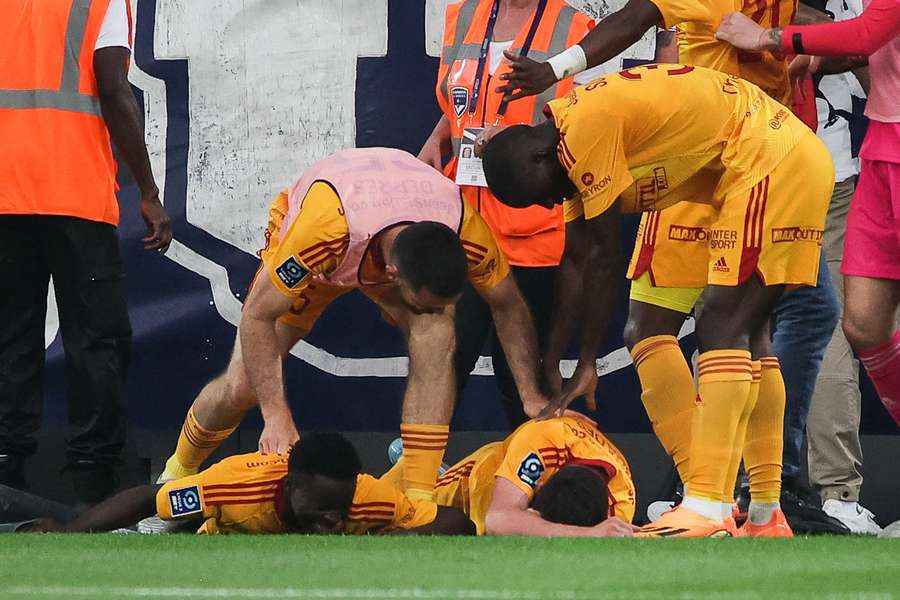 Rodez' French midfielder Lucas Buades (C) lies on the ground after being hit by a projectile 