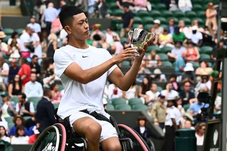 Japan's Tokito Oda looks at his trophy after beating Britain's Alfie Hewett during their men's wheelchair singles final tennis match
