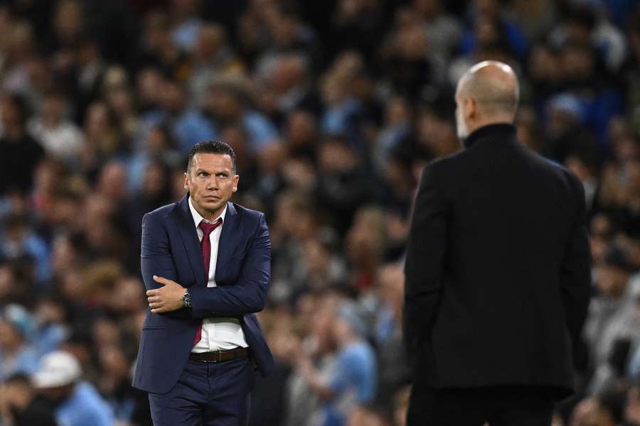 El entrenador israelí del Estrella Roja, Barak Bakhar (izq.), reacciona ante el entrenador español del Manchester City, Pep Guardiola.