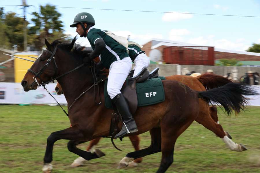 A man riding on the back of a brown horse