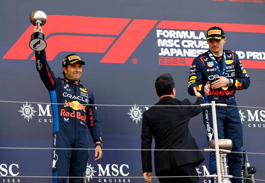 Red Bull's Sergio Perez celebrates with the trophy on the podium after finishing second in the Japanese Grand Prix