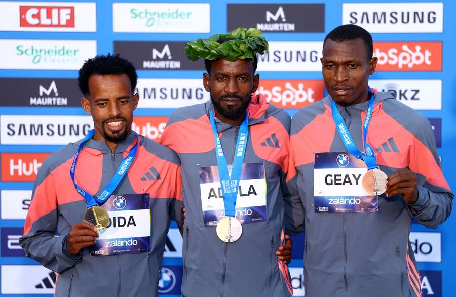 Guye Adola festeggia sul podio dopo aver vinto la gara maschile con il secondo classificato Gemechu Dida Diriba e il terzo classificato Gabriel Geay