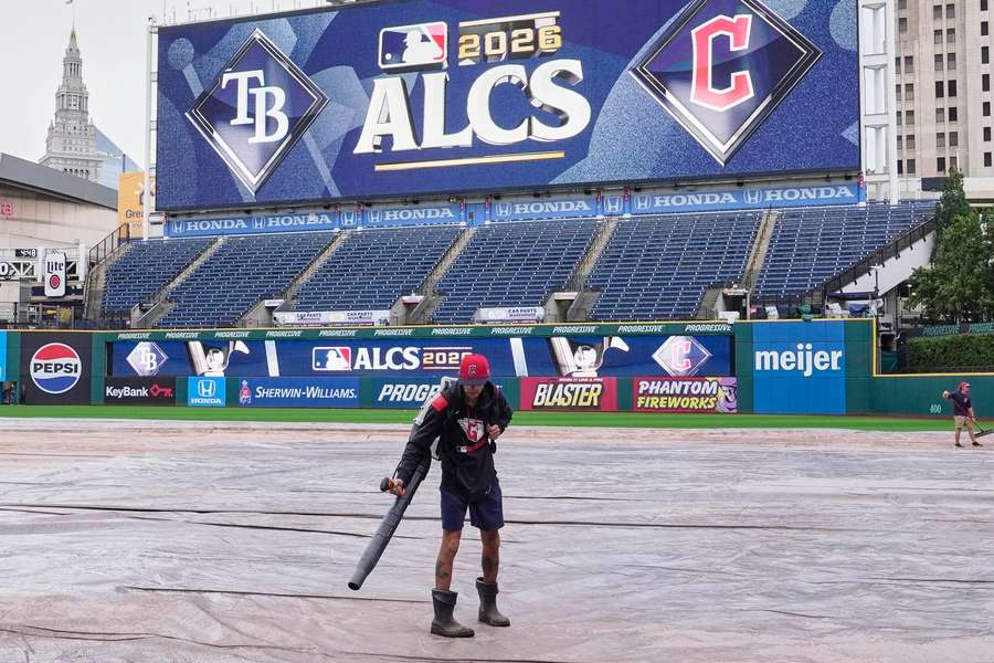 Groundscrewman dries off the tarp at Progressive Field in Cleveland a day ahead of ALCS Game 3 Groundscrewman dries off the tarp at Progressive Field in Cleveland a day ahead of ALCS Game 3