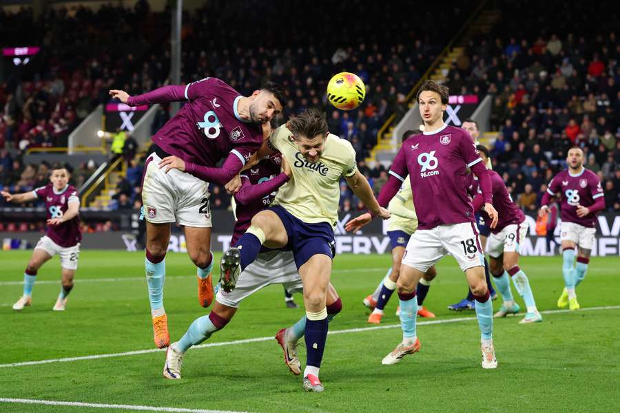 Armando Broja, del Burnley, remata de cabeza presionado por James Tarkowski, del Everton