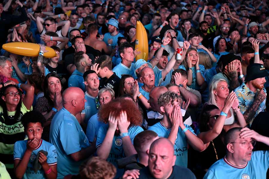 Man City fans react in the 4TheFans Fan Park in Manchester