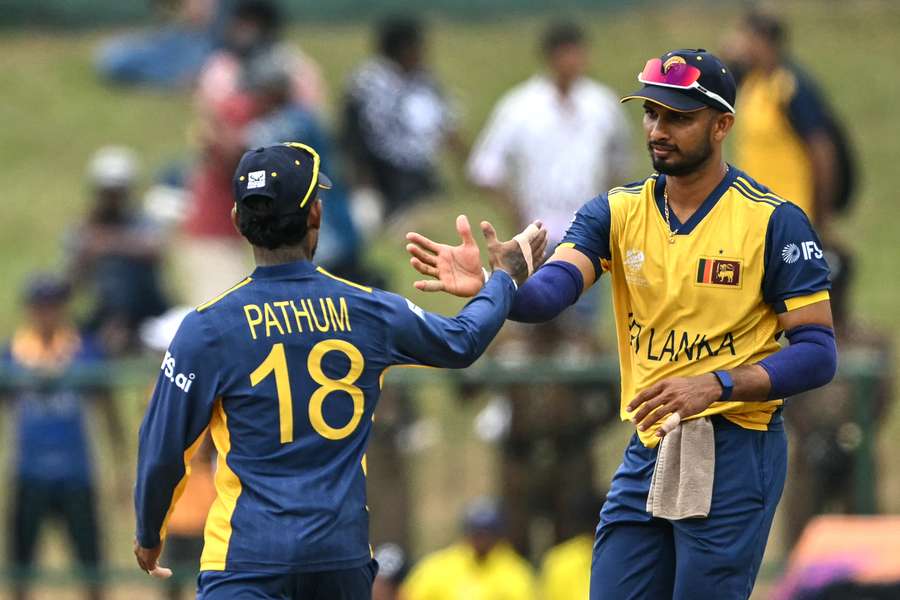 Sri Lanka's captain Dasun Shanaka (R) and his teammate Pathum Nissanka shake hands after their team's win