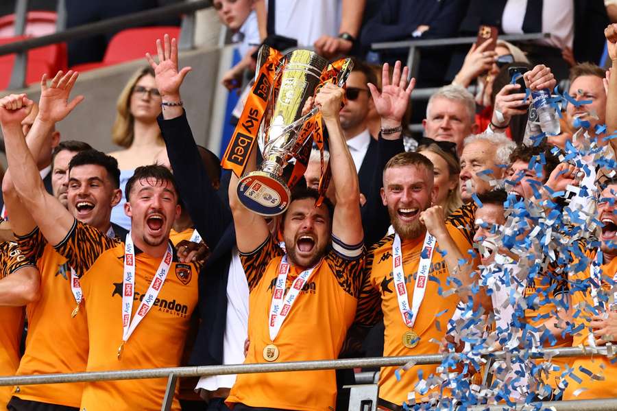Lewie Coyle and teammates celebrate with the trophy after winning the Championship play-off final Lewie Coyle and teammates celebrate with the trophy after winning the Championship play-off final