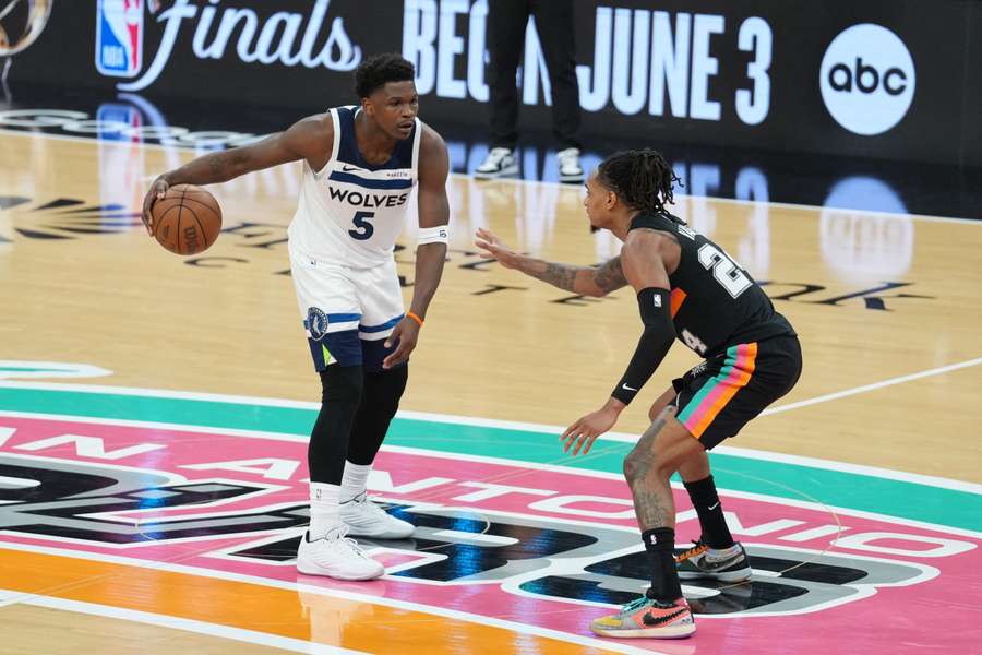 Minnesota Timberwolves guard Anthony Edwards dribbles against San Antonio Spurs guard Devin Vassell