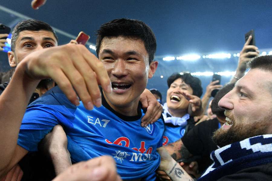 Napoli's Kim Min-jae celebrates with fans on the pitch after winning Serie A