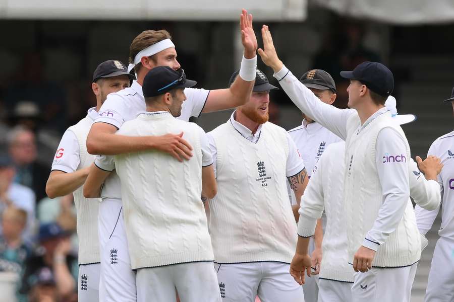 England's Stuart Broad (2L) celebrates with teammates after taking the wicket of Australia's Travis Head