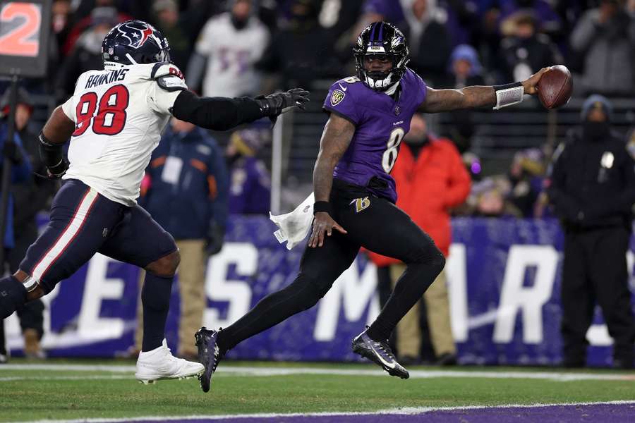 Lamar Jackson of the Baltimore Ravens scores an eight-yard touchdown against Sheldon Rankins of the Houston Texans
